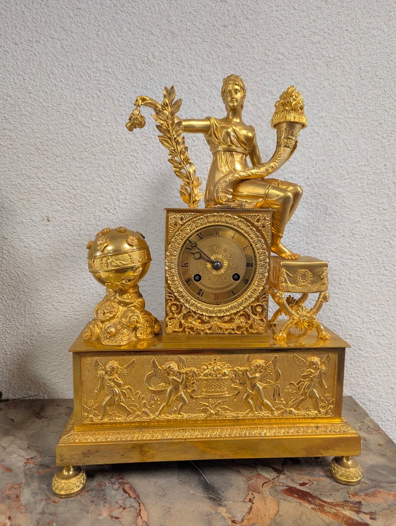 Pendule Empire bronze doré allégorie — L'Horlogerie d'Antan Bordeaux